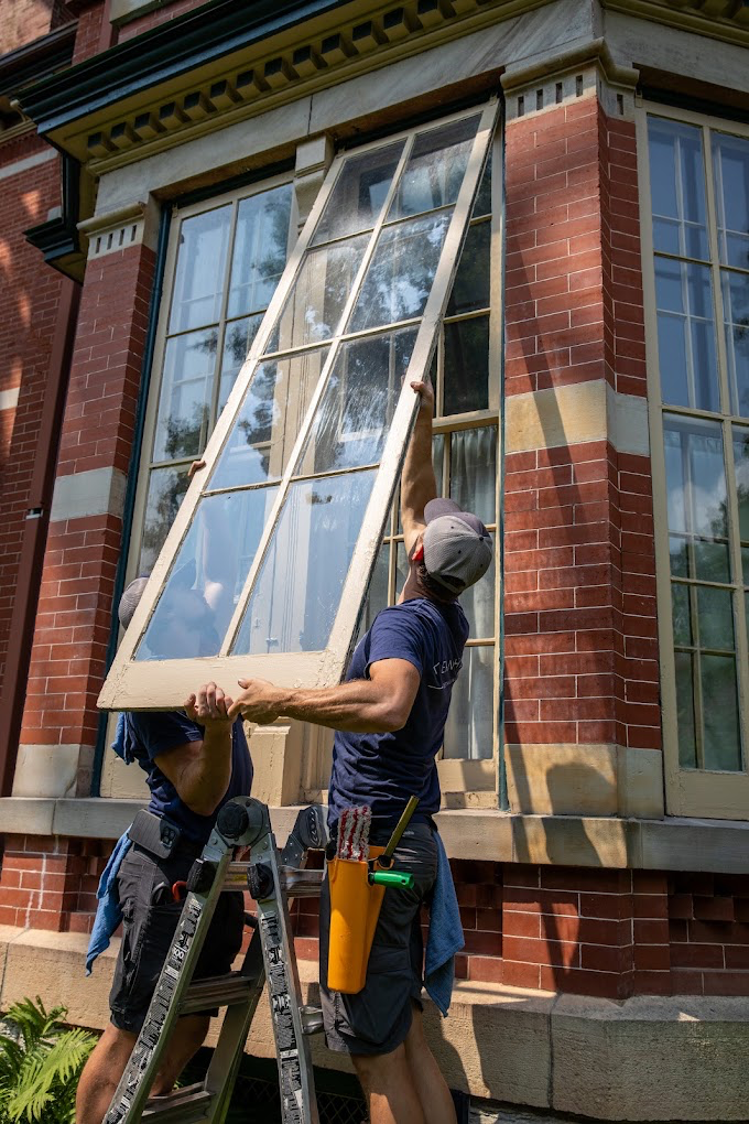 Klean Home Detailing crew removing a large window sash for repair